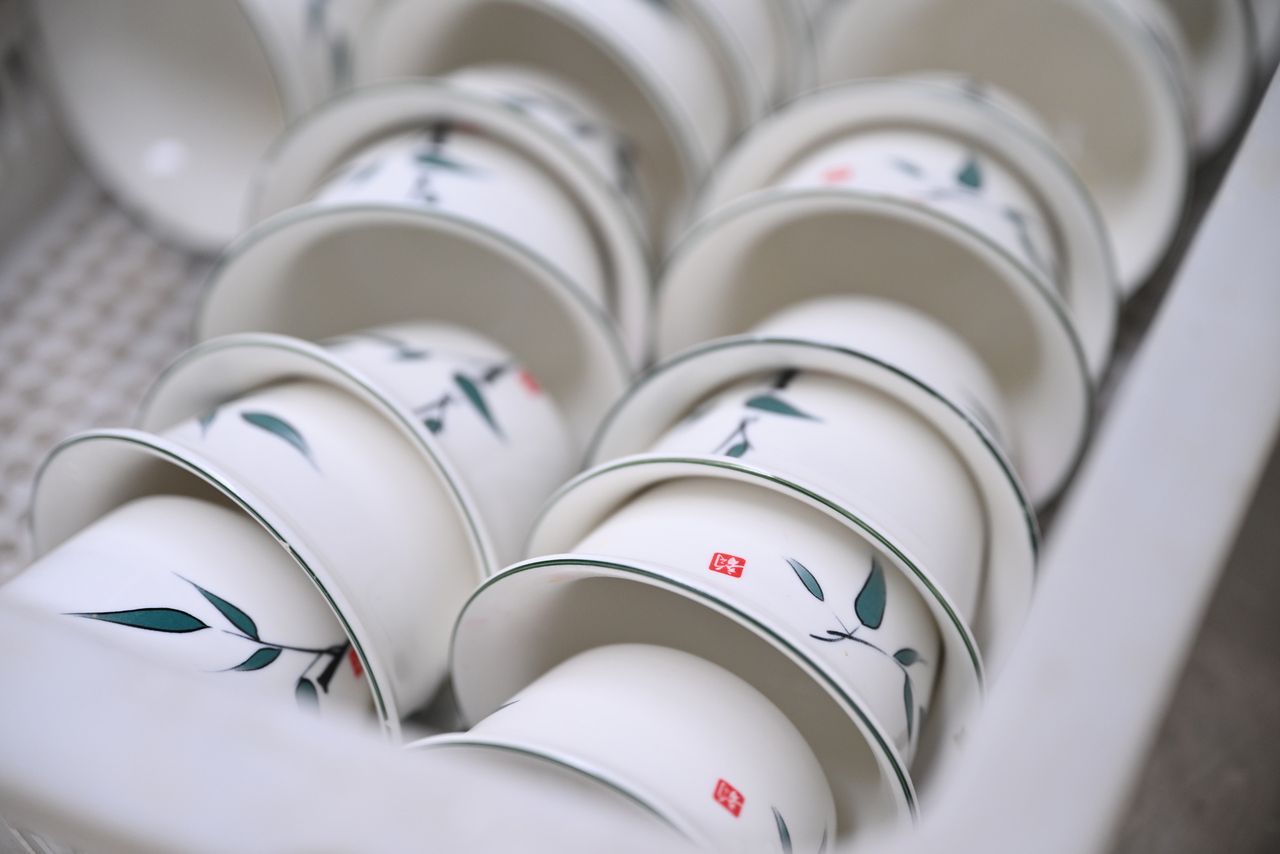 A stack of white ceramic bowls featuring delicate floral patterns, perfect for kitchen decor.